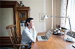 Woman sitting at desk in front of laptop