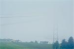 Misty view of electricity cables and  pylon next to houses, Haugesund, Rogaland County, Norway