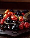 Still life of strawberries, raspberries and blackberries on spoon