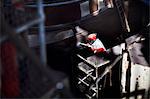 Worker cleaning boat with high pressure hose in shipyard