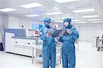 Male worker holding flex circuit in flexible electronics factory clean room