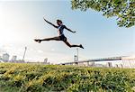 Young woman training in park, New York, USA