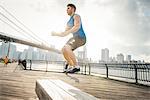 Young man doing jump training on riverside, Brooklyn, New York, USA