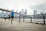 Group of people running in front of Brooklyn bridge, New York, USA