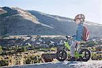 Boy sitting on balance bike in front of mountain, Draper cycle park, Missoula, Montana, USA