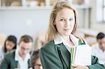 Student in classroom, classmates in background