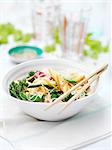 Bowl of mixed vegetables, baby sweetcorn, courgettes, broccoli, mangetout, red pepper and noodles on garden table