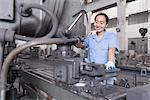 Female factory worker working on machine in crane factory, China