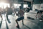 Male crossfitter training with barbell in gym