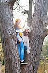 Teenage girls standing in tree looking away smiling