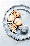 Overhead view of shortbread cookies tied with white ribbon on silver serving dish