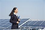 Businesswoman on roof of solar panel assembly factory, Solar Valley, Dezhou, China