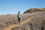 Female runner moving down hill path