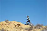 Female runner running up rugged hill