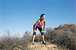 Exhausted female runner on top of hill