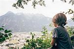 Rear view of boy looking at view of mountain range, Bludenz, Vorarlberg, Austria