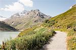 Pathway by water to mountain range, Partenen, Vorarlberg, Austria