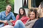 Four adult friends chatting outside cabin