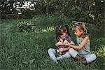 Two young girls collecting apples on farm