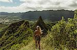 Rear view of woman on grass covered mountain, Oahu, Hawaii, USA