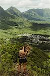 Rear view of woman on grass covered mountain, Oahu, Hawaii, USA