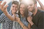 Young adult friends taking selfie at roof terrace party