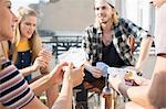 Young adults playing card game at roof terrace party, Budapest, Hungary