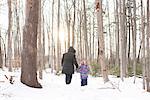 Mother and daughter walking in snow, Peterborough, Ontario