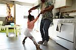 Father and daughter jiving in kitchen