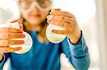 Girl doing science experiment, holding flasks of liquid