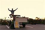 Man taking smartphone selfie in back of pickup truck at Newport Beach, California, USA