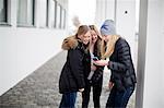 Happy girls looking at cell phone