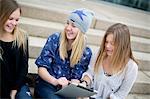 Smiling girls using digital tablet