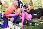 Women with children exercising in park