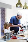 Grandfather and granddaughter preparing food