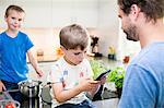 Boy playing with smartphone in kitchen