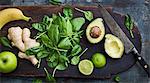 Avocado, spinach, ginger, apple and banana on cutting board
