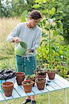 Woman watering plants in pots