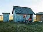 People having meal in front of wooden house