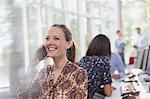 Smiling businesswoman talking on cell phone in office