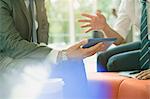 Businessmen meeting using digital tablet, talking and gesturing