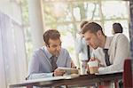 Businessmen using digital tablet at office table