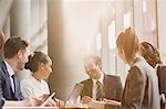 Smiling businessman leading conference room meeting