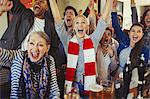 Enthusiastic sports fans cheering watching game in bar