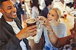 Enthusiastic friends toasting beer and wine glasses at bar