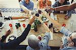 Overhead view friends toasting wine glasses at restaurant table