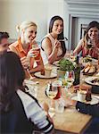 Friends talking and dining at restaurant table