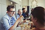 Friends talking and eating at restaurant table