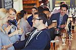 Enthusiastic man and woman greeting in bar