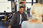 Smiling man talking to woman in bar